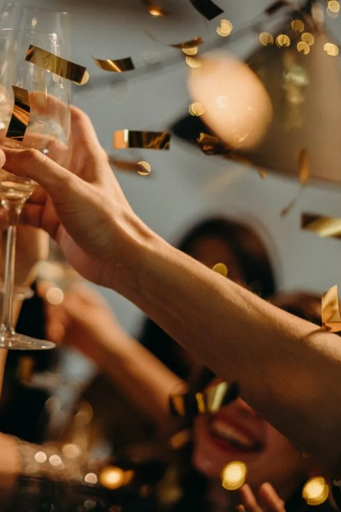 Coupes de champagne levées et confettis dorés lors d'une soirée
